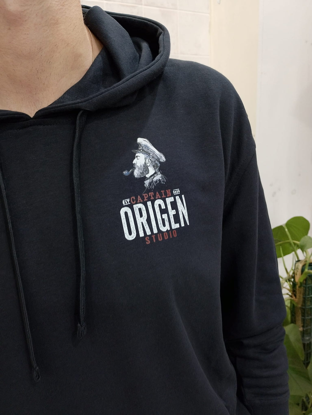 Detalle del estampado Captain Origen en sudadera negra, con ilustración y texto serigrafiado