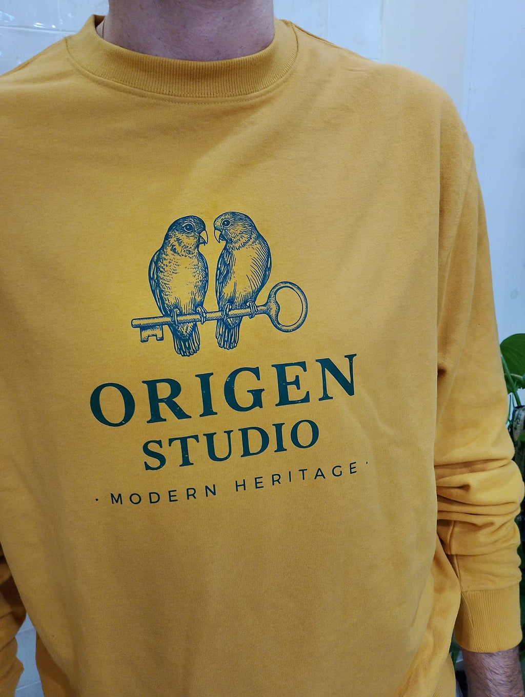 Detalle del estampado Heritage Birds en sudadera mostaza de Origen Studio