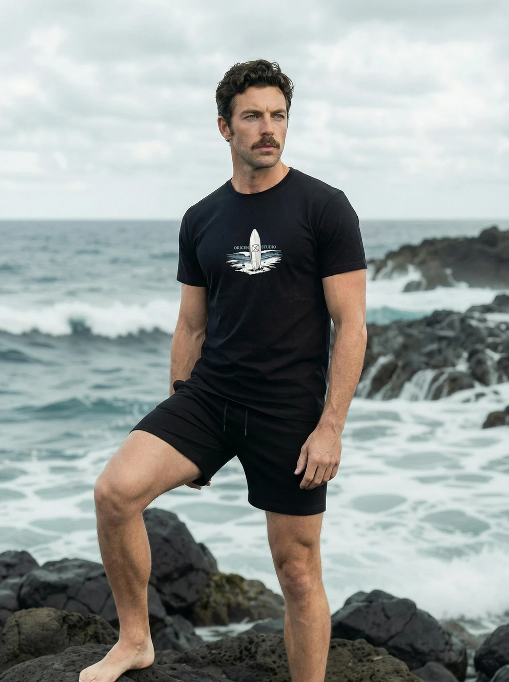 Camiseta negra hombre Origen Studio look verano con pantalón corto en playa