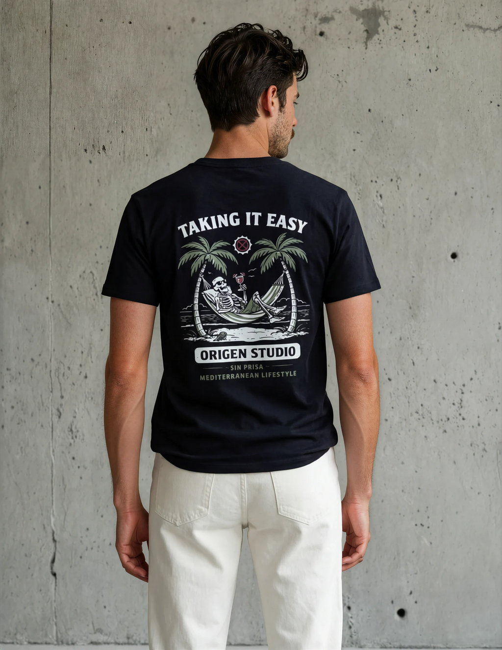 Espalda de camiseta negra con gráfico de un esqueleto en una hamaca con palmeras y el texto "Taking It Easy - Origen Studio".