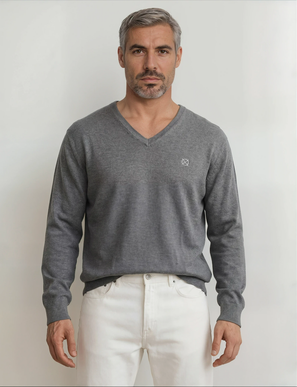 Detalle frontal del jersey gris cuello V de hombre Origen Studio con logo minimalista bordado en el pecho.