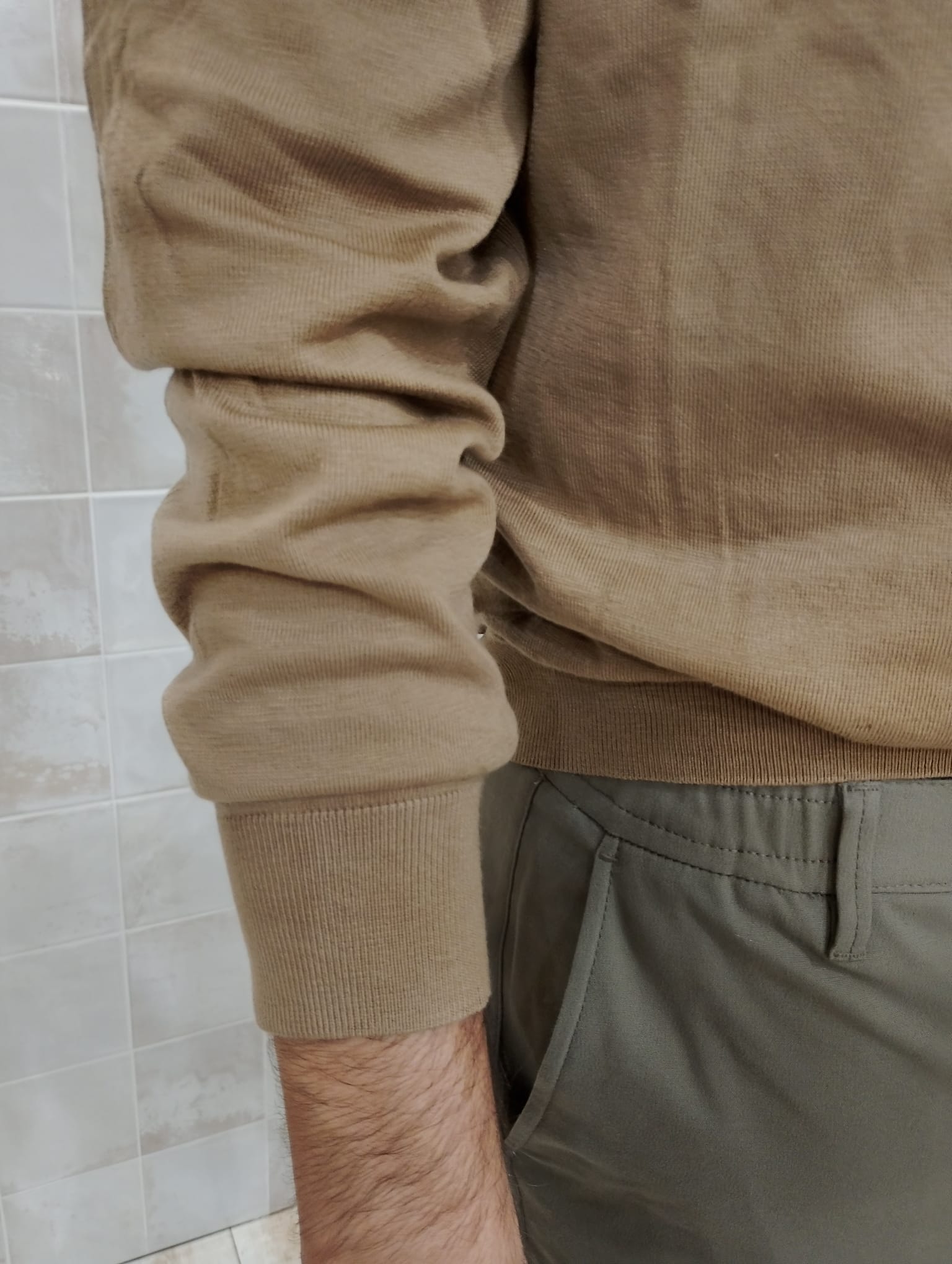 Detalle del tejido y la manga del jersey color tierra de ORIGEN STUDIO.