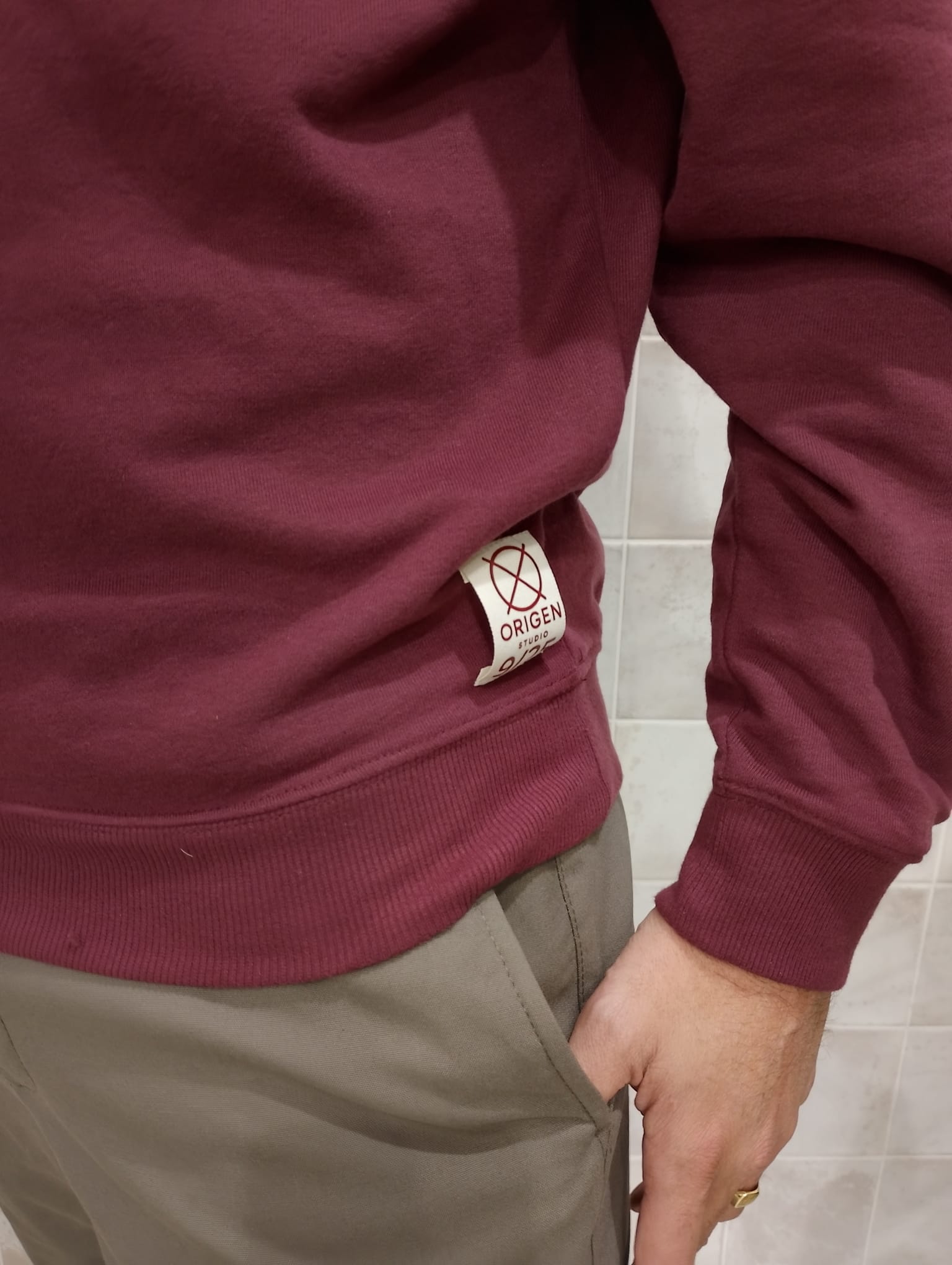 Detalle lateral de la sudadera burdeos Origen Studio con etiqueta numerada edición limitada.