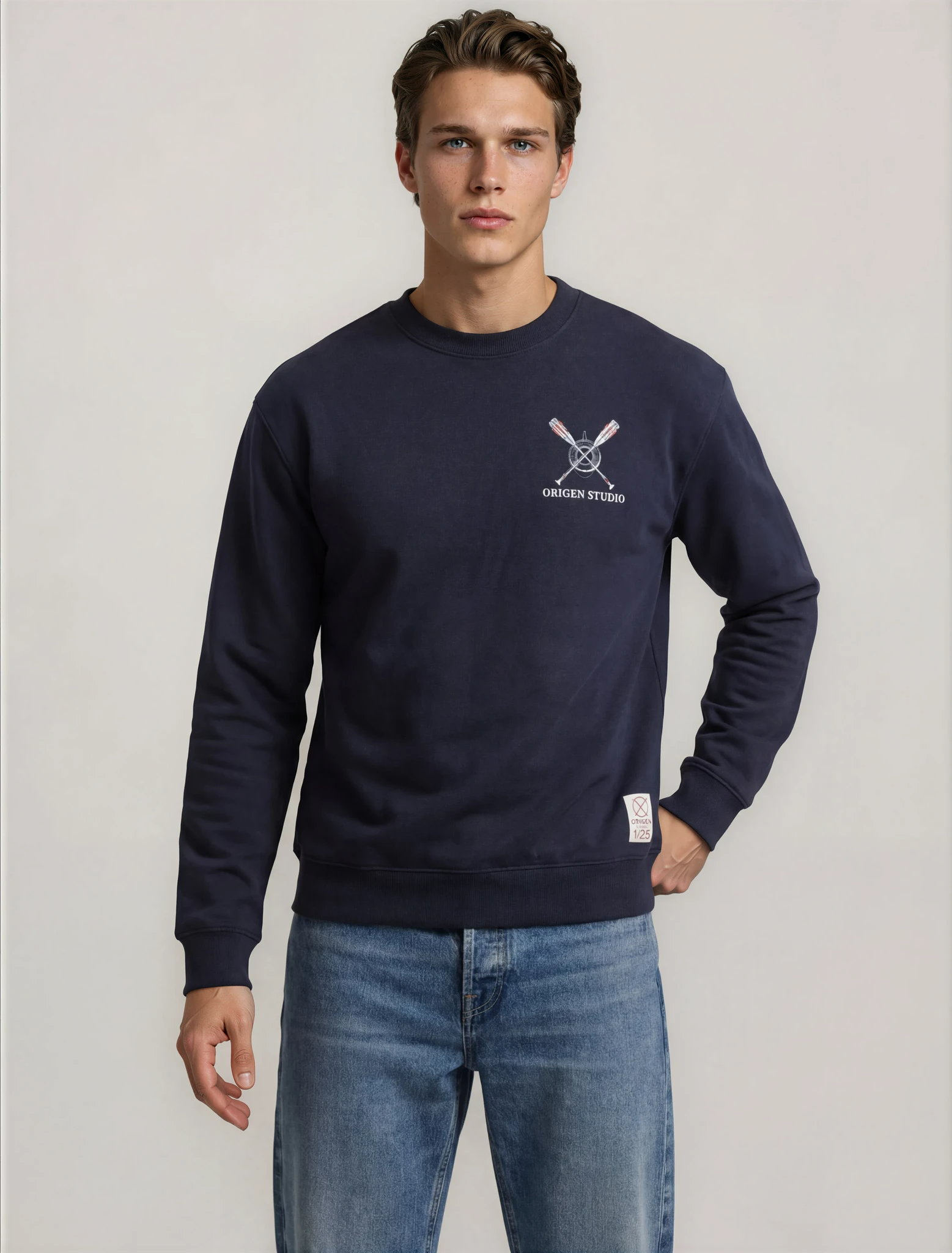 Detalle del logo bordado en el pecho de la sudadera azul marino Origen Studio Le Défi de Zumaia.