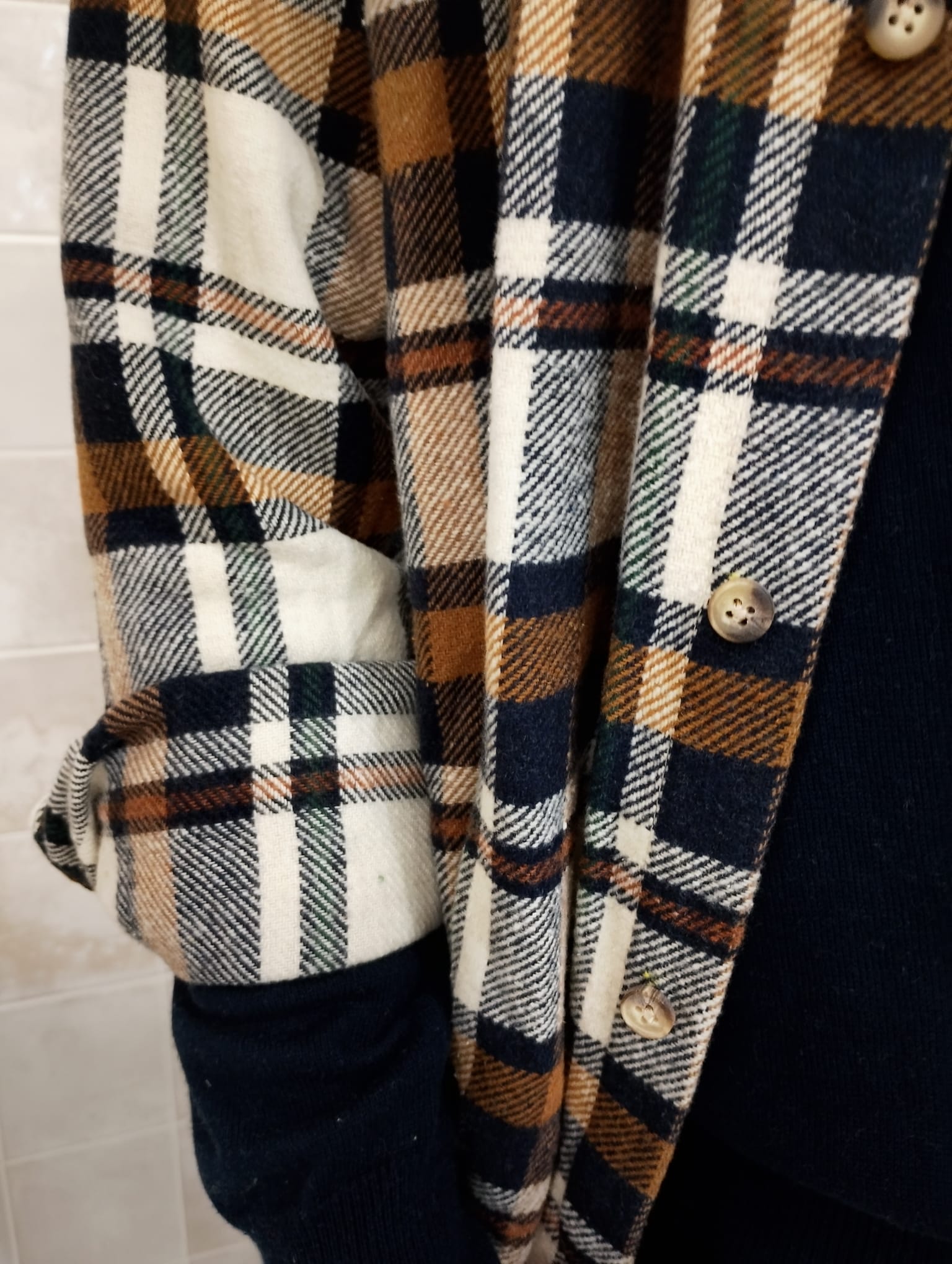 Detalle de la manga y textura del tejido de la sobrecamisa de cuadros Origen Studio